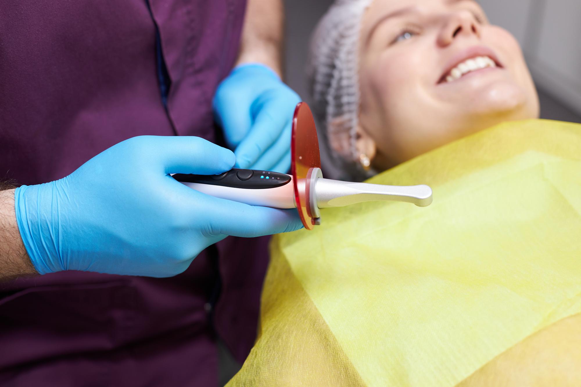Selective focus on modern dental equipment an ultraviolet lamp for tooth filling in dentist's hand — por TriangleProd no Freepik