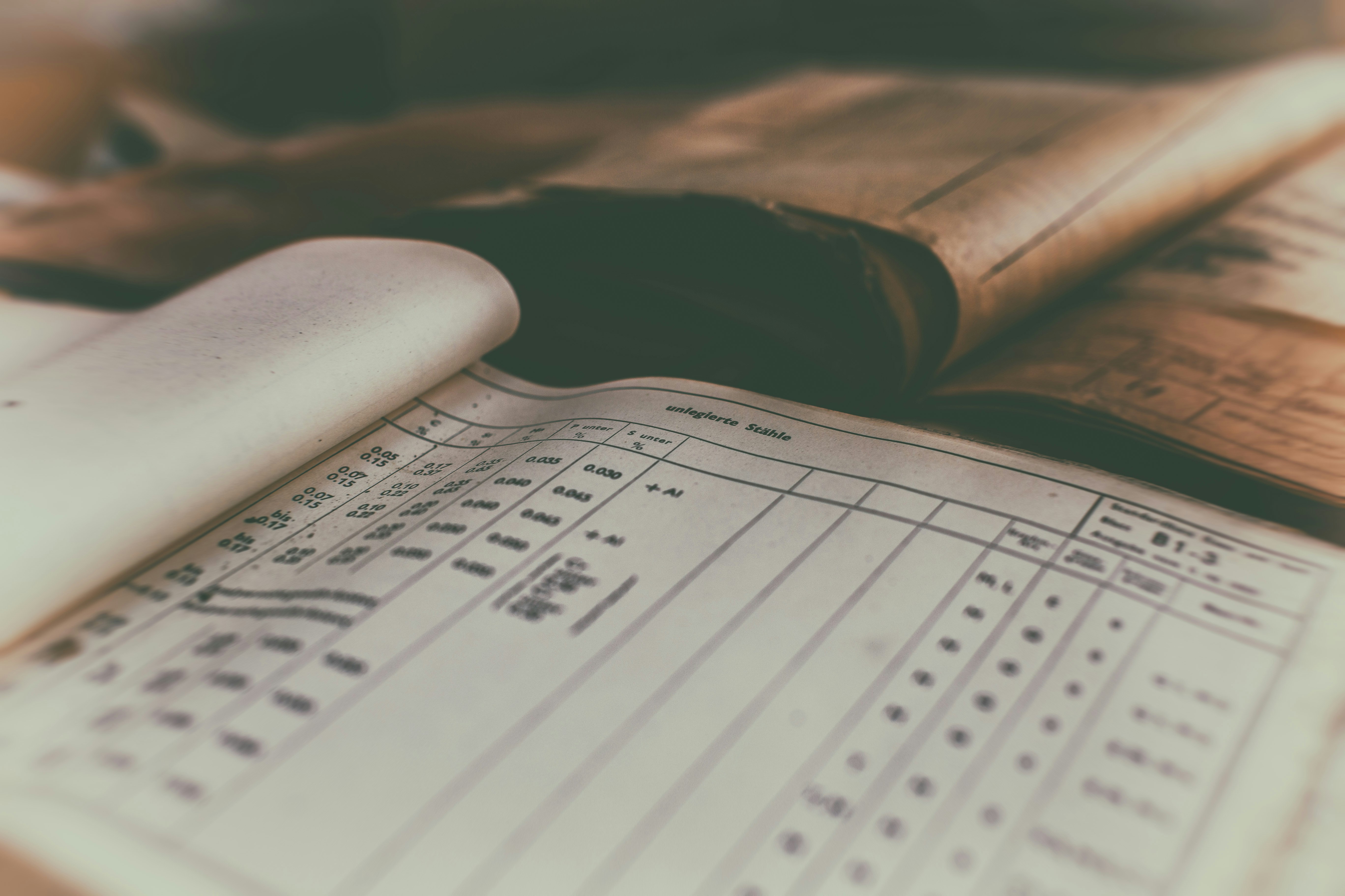 Pen poised over a check, ready to write. — por Money Knack no Unsplash